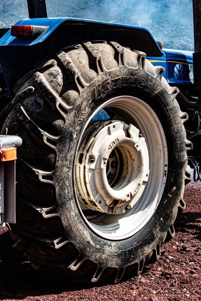 Detailed close-up of a dirty, rugged tractor tire on a farm.